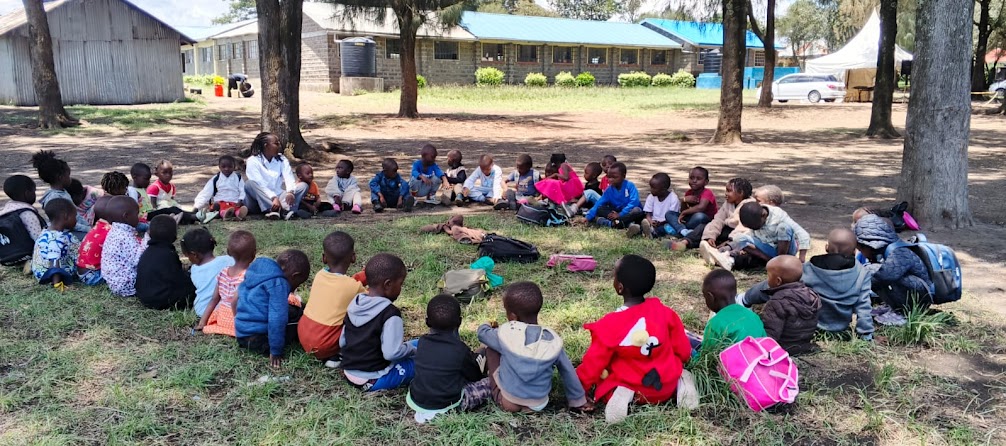 Abigail Wamaitha leading an outdoor learning circle with children at CAN